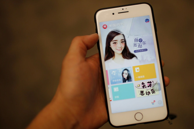 A woman shows her selfie decorated by Meitu application at a cafe, in Beijing, China, March 22, 2017.  Picture taken March 22.