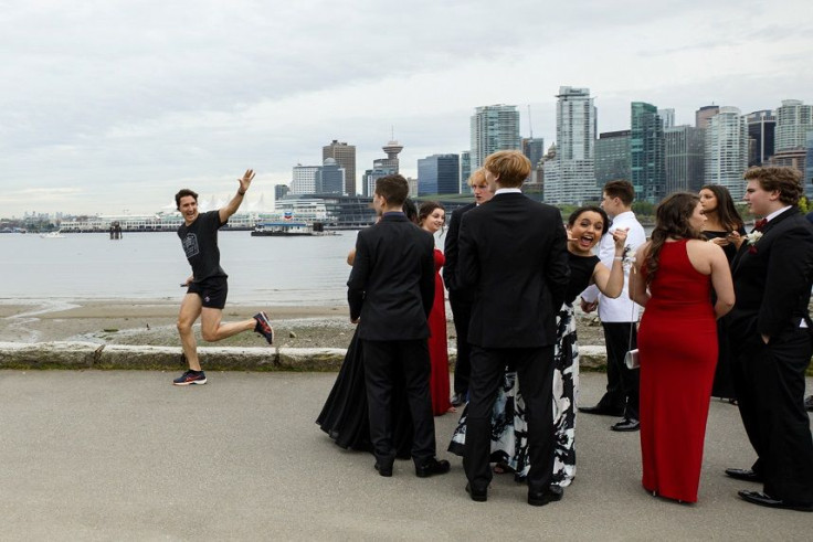 Prime Minister Justin Trudeau jogs past a group of high school students dressed for their prom