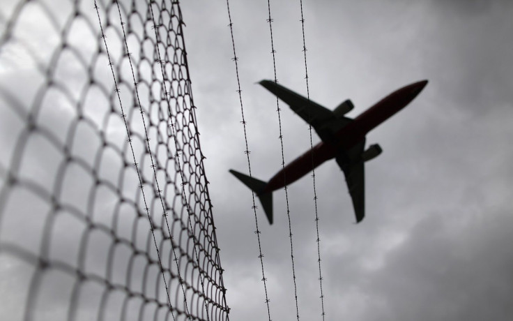 A passenger plane flies over a barbed wire fence as it approaches Sydney airport February 23, 2010.