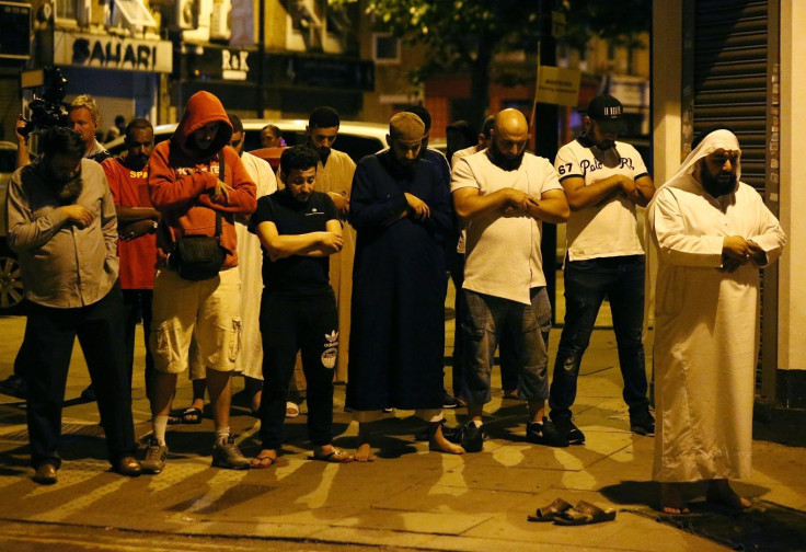 Men pray after a vehicle collided with pedestrians near a mosque in the Finsbury Park neighborhood of North London, Britain June 19, 2017.