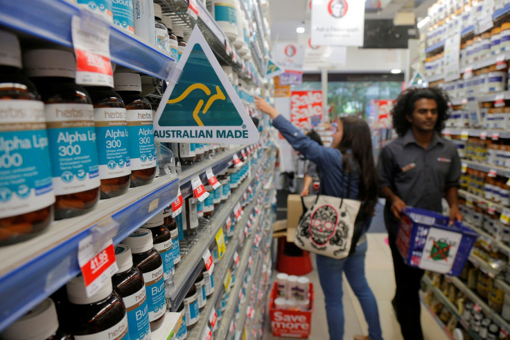A shopper (L) browses for health products in an aisle stocked with vitamin supplements at a Mr Vitamins store in Sydney, Australia, March 9, 2017.