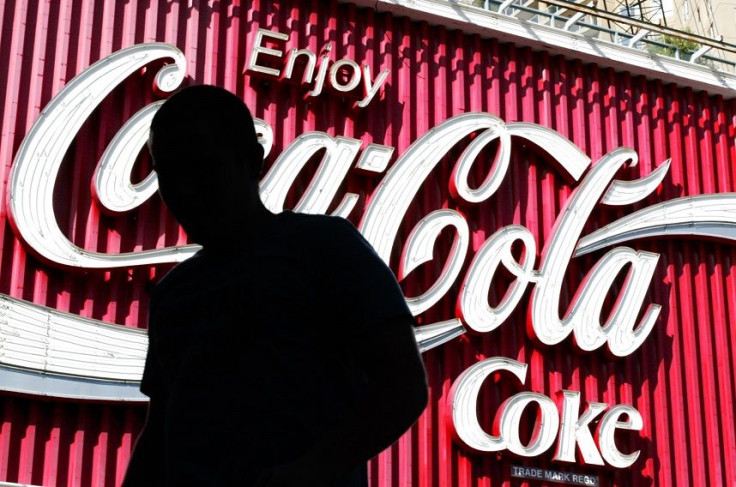 A pedestrian in Sydney passes a large Coca-Cola sign in the city's east August 3, 2004.