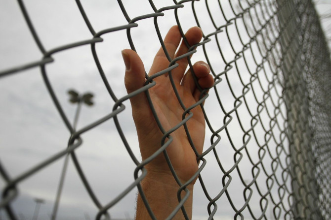 An inmate serving a jail sentence rests his hand on a fence at Maricopa County's Tent City jail in Phoenix July 30, 2010.