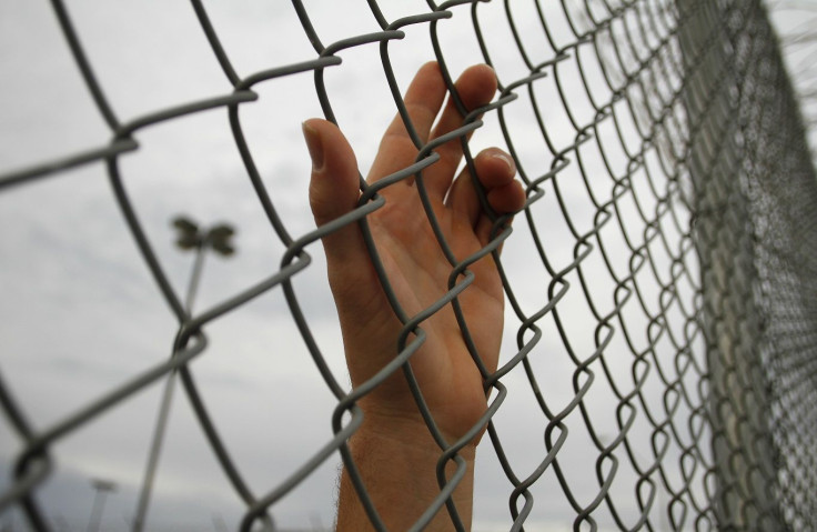 An inmate serving a jail sentence rests his hand on a fence at Maricopa County's Tent City jail in Phoenix July 30, 2010.