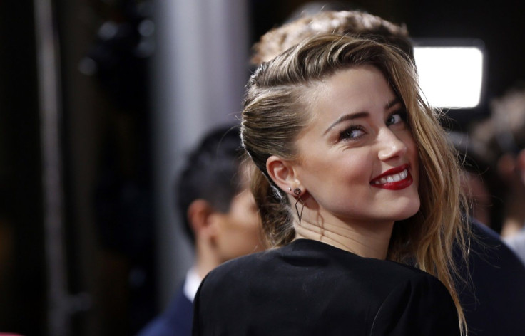 Cast member Amber Heard smiles at the premiere of "3 Days to Kill" in Los Angeles, California February 12, 2014.