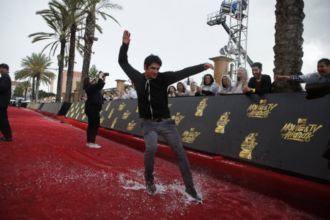 Teen Wolf star Tyler Posey slides around the arrivals area following a storm at the 2017 MTV Movie and TV Awards RTS15KZG