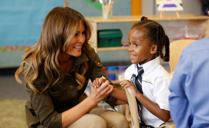 U.S. first lady Melania Trump clasps hands with a child as she visits the Joint Base Andrews Youth Center in Maryland, U.S., September 15, 2017.