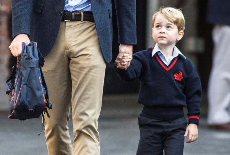 Prince George holds his father Britain's Prince William's hand as he arrives on his first day of school at Thomas's school in Battersea, London, September 7, 2017.