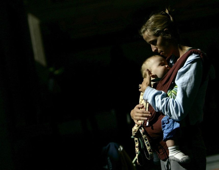 A nursing mother holds her son in front of the Delta airlines counter during a protest at Fort Lauderdale airport, Florida November 21, 2006.