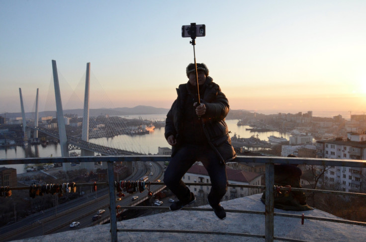 A man takes a selfie against Golden Horn Bay in the city of Vladivostok, Russia February 19, 2018.