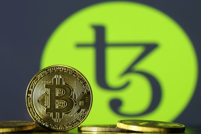 Photo illustration shows copies of Bitcoins seen in front of Tezos logo, October 10, 2017. Picture taken October 10, 2017.