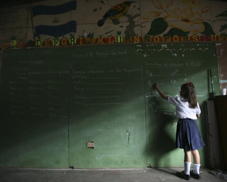 A girl writes on a chalk board during the opening of the elementary school year in the old center of Managua February 4, 2008.