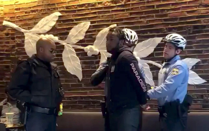 Police officers detain a man inside a Starbucks cafe in Philadelphia, Pennsylvania, U.S., April 12, 2018 in this picture grab obtained from social media video. Picture taken April 12, 2018.