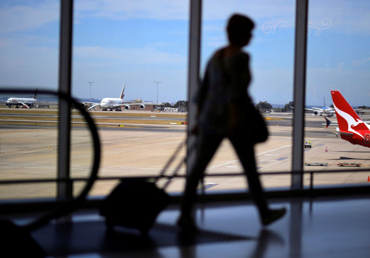 A passenger walks with their luggage towards a Qantas Airways plane at Sydney International Airport in Australia, October 25, 2017. Picture taken October 25, 2017.