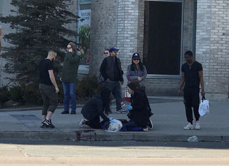 A victim is helped by pedestrians after a van hit multiple people at a major intersection in Toronto, Canada April 23, 2018, in this picture obtained by Reuters