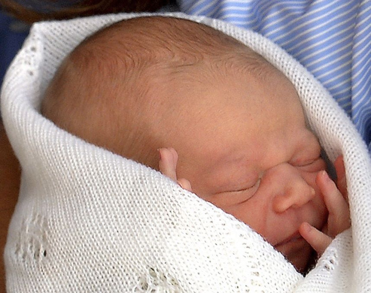 Britain's Prince William holds his baby son outside the Lindo Wing of St Mary's Hospital before leaving with Catherine, Duchess of Cambridge, in central London July 23, 2013.