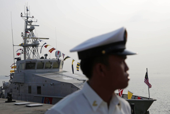 A Malaysian naval officer stands in front of a Bay Class Vessel patrol boat before a handover ceremony in Port Klang, February 27, 2015.