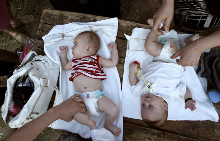 Children are dressed after a mass baptism ceremony in the town of Mtskheta outside Tbilisi, July 13, 2010.