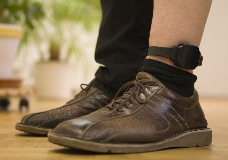 An official demonstrates the wearing of an electronic monitoring ankle-bracelet in Bern November 26, 2009.