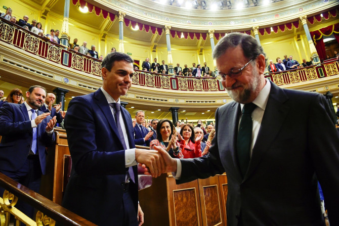 Spain's new Prime Minister and Socialist party (PSOE) leader Pedro Sanchez shakes hands with ousted Prime Minister Mariano Rajoy