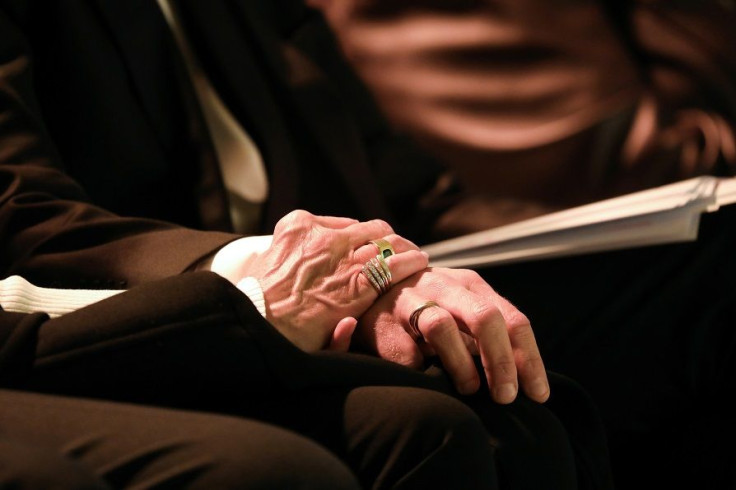 The hands of French President Emmanuel Macron (R) and his wife Brigitte Macron