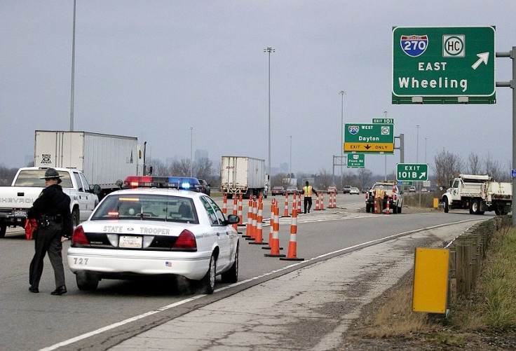 A state trooper stands next to her car as the Ohio State Highway Patrol