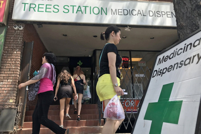 Two women enter the Trees Station, a medical marijuana dispensary, as others walk past in Toronto, Ontario, Canada May 28, 2018. Picture taken May 28, 2018.