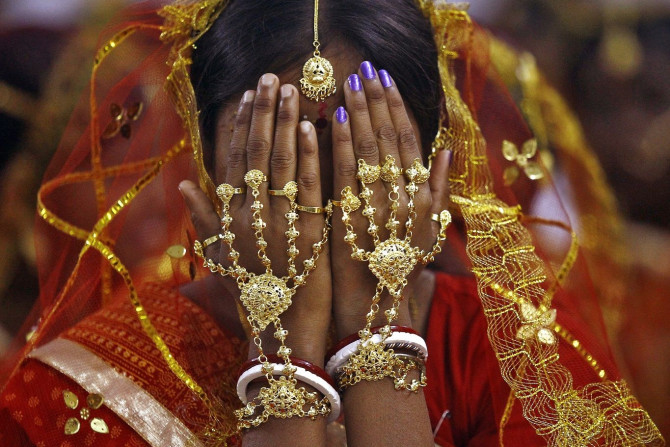 A bride covers her face as she waits to take her wedding vow at a mass marriage ceremony at Bahirkhand village, north of Kolkata February 8, 2015.
