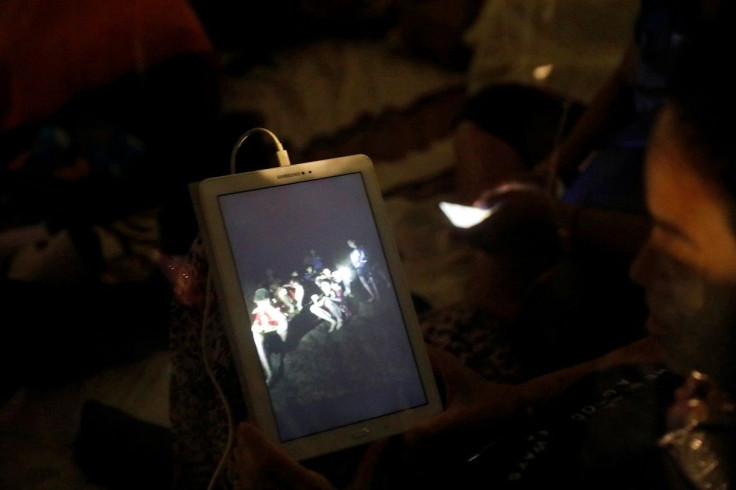 A family member looks at a photo near Tham Luang cave complex, as members of under-16 soccer team and their coach