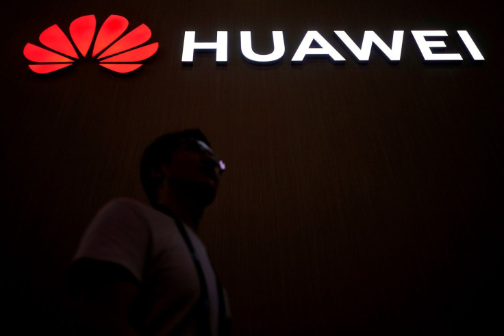 FILE PHOTO: A man walks past a sign board of Huawei at CES (Consumer Electronics Show) Asia 2018 in Shanghai, China June 14, 2018.