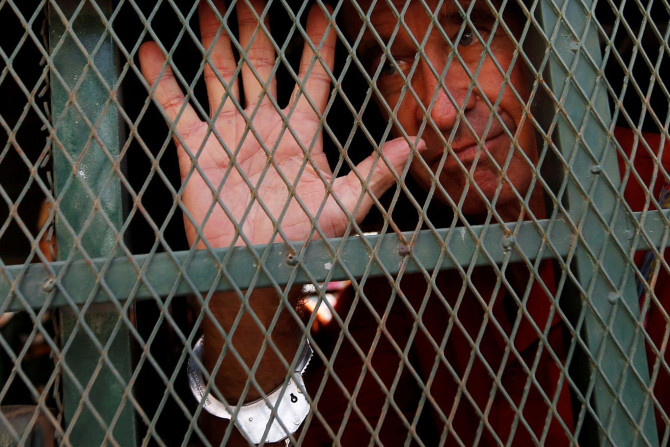 Australian filmmaker James Ricketson gestures inside a prison truck as he arrives at the Municipal Court of Phnom Penh, Cambodia, June 15, 2018.