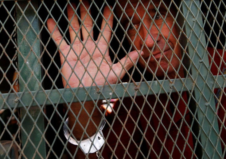 Australian filmmaker James Ricketson gestures inside a prison truck as he arrives at the Municipal Court of Phnom Penh, Cambodia, June 15, 2018.