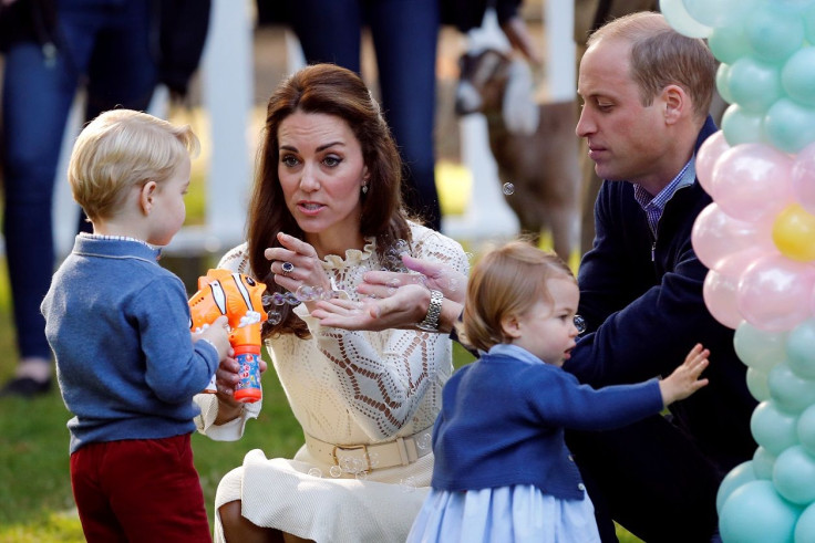 Britain's Prince William and Catherine, Duchess of Cambridge, look on as Prince George plays with a bubble gun and Princess Charlotte