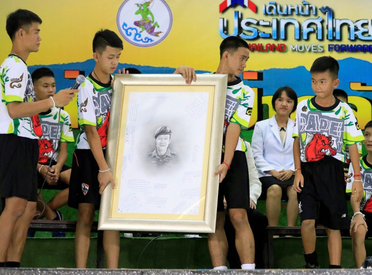 A 'Wild Boars' soccer player holds a portrait of former Navy SEAL diver Saman Kunan