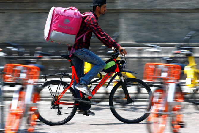A food delivery driver for Foodora cycles in downtown Milan, Italy, May 18, 2018.