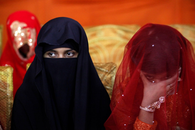 A bride sits with a companion during a mass wedding ceremony in Karachi, Pakistan May 9, 2016.