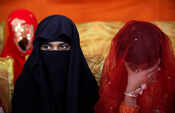 A bride sits with a companion during a mass wedding ceremony in Karachi, Pakistan May 9, 2016.