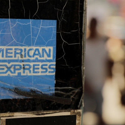 Pedestrians walk past an American Express sign in New York U.S., July 16, 2018.