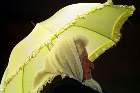 An elderly lady shields herself from the sun with an umbrella while waiting for a bus in Sydney October 14.