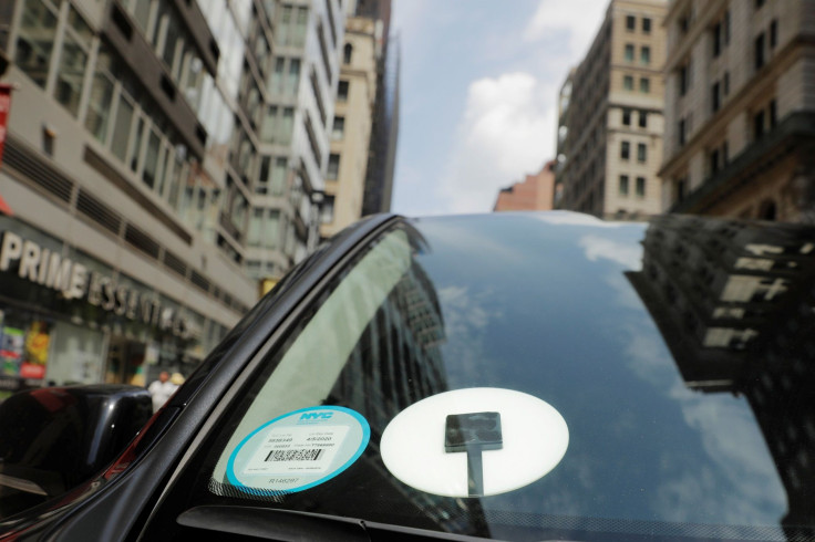 A car with an Uber logo on it drives down the street in New York, U.S., July 27, 2018.