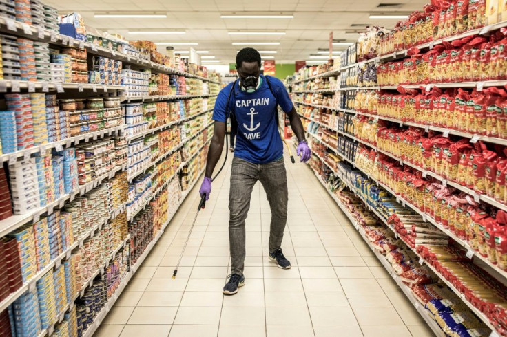 A man disinfects an empty supermarket in Dakar