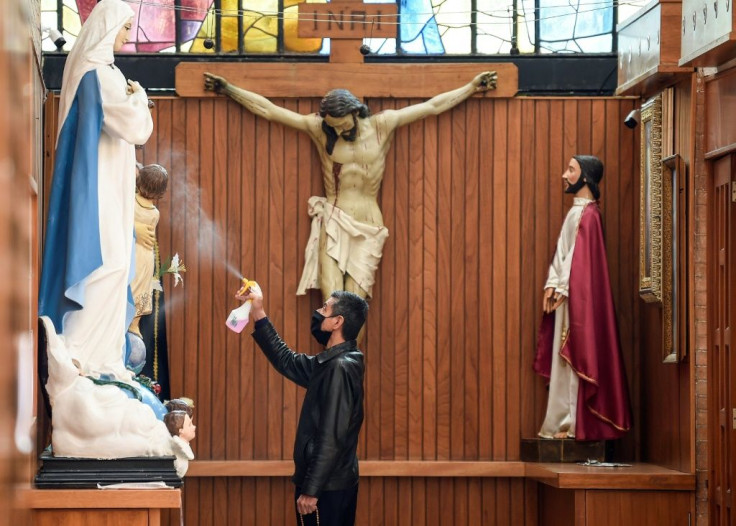 A sacristan wearing a face mask disinfects the religious statues inside the Sagrada Familia Church in Mexico City