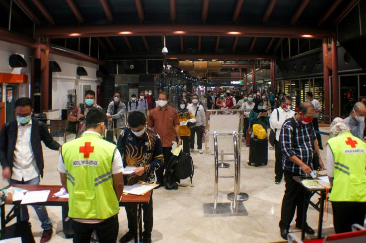Airport health officials check passengers for required travel documents, such as a COVID-19 test certificate, at Soekarno-Hatta Jakarta International airport in Tangerang