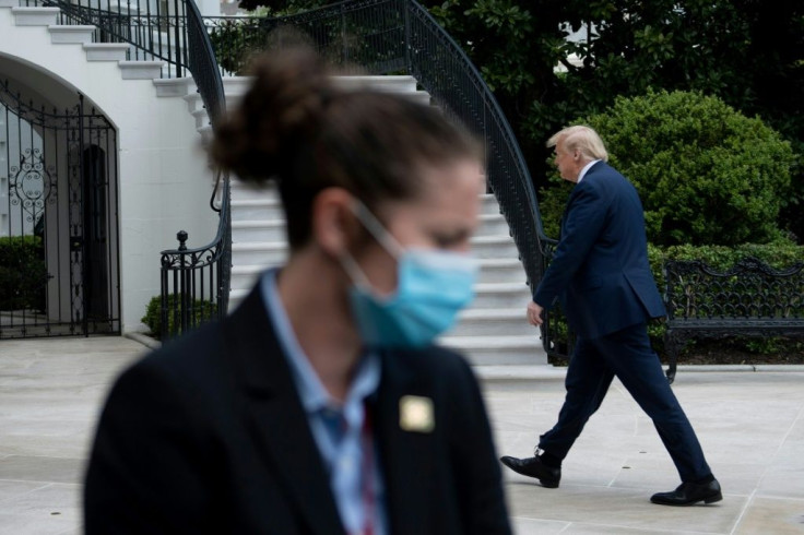 US President Donald Trump walks from Marine One to the White House as a secret service agent wearing a face mask looks in Washington, DC