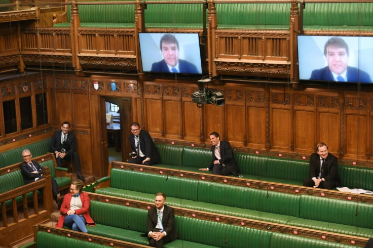 A handout photograph from the UK Parliament shows MPs sitting apart observing social distancing in the House of Commons in London during Prime Minister's Questions.