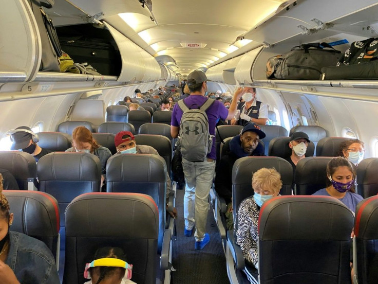 Passengers, all but one wearing masks, board an American Airlines flight from New York to Charlotte, North Carolina, on May 3, 2020
