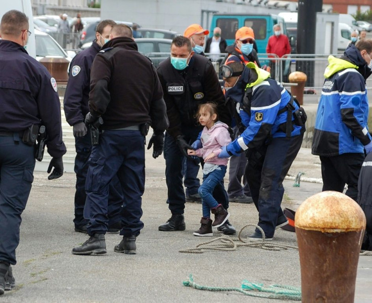 French police, wearing protective masks against the coronavirus, with young migrants picked up off Calais as they tried to get to Britain by boat