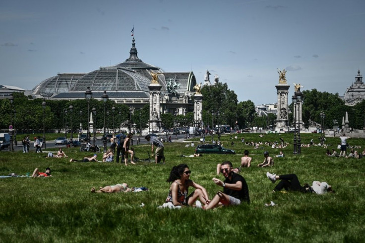 People enjoy a sunny day near the Grand Palais and the Pont Alexandre III bridge in Paris as France partially lifts restrictions