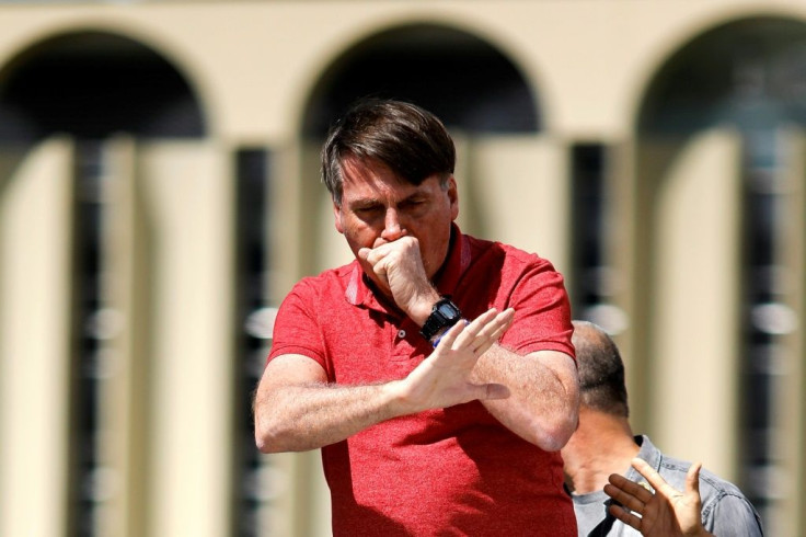President Jair Bolsonaro coughs during a speech to supporters in Brasilia at an April protest against virus lockdown measures imposed by states and cities