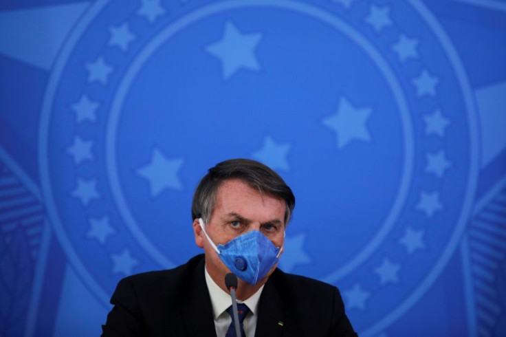 Brazil's President Jair Bolsonaro wears a face mask during a press conference on the coronavirus pandemic at the Planalto Palace in Brasilia